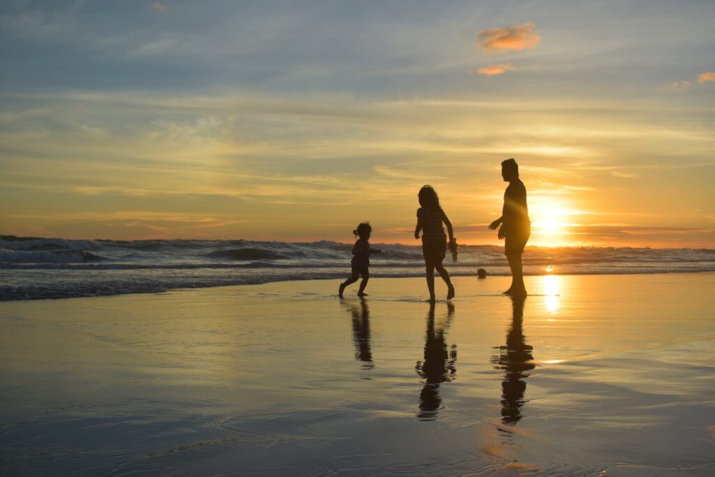 family on beach at sunset