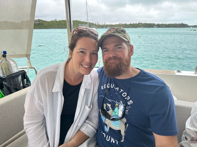 Happy couple on a boat, enjoying a day out, showcasing support for military families and veterans.